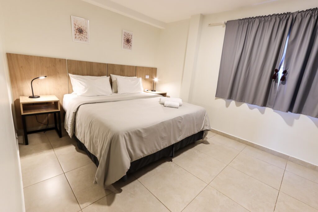 Habitación luminosa con cama king size y veladores, departamento A en Ushuaia