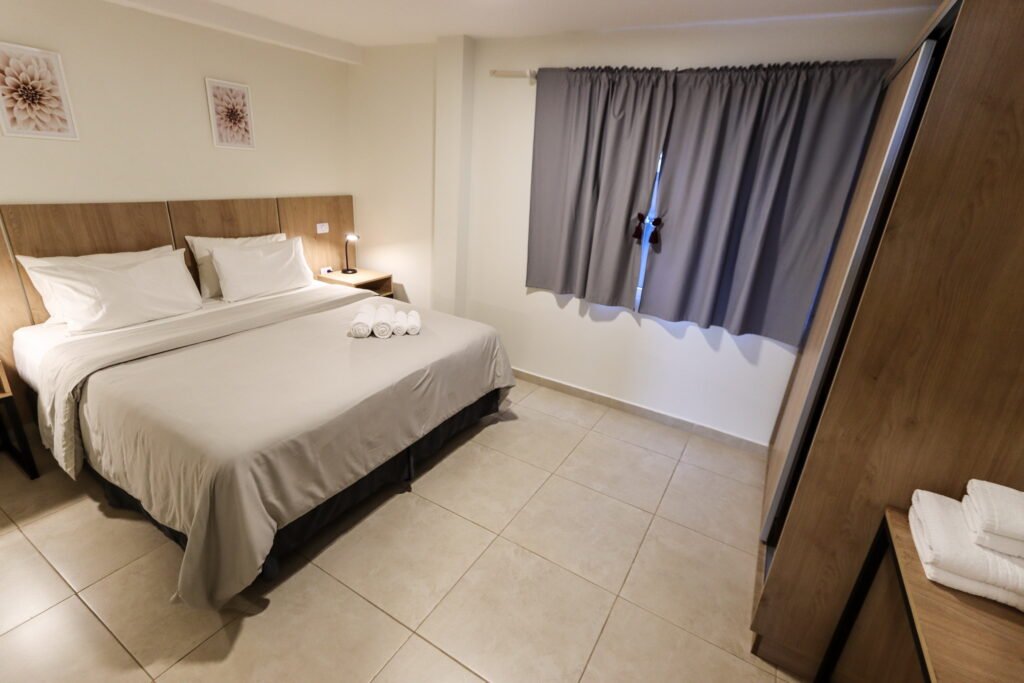 Dormitorio apartamento A, cama king size, placard con mesa escritorio