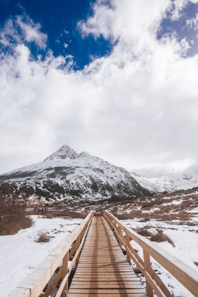 Explore the snowy landscape of Ushuaia, Argentina with this scenic winter footpath leading to snow-capped mountains.
