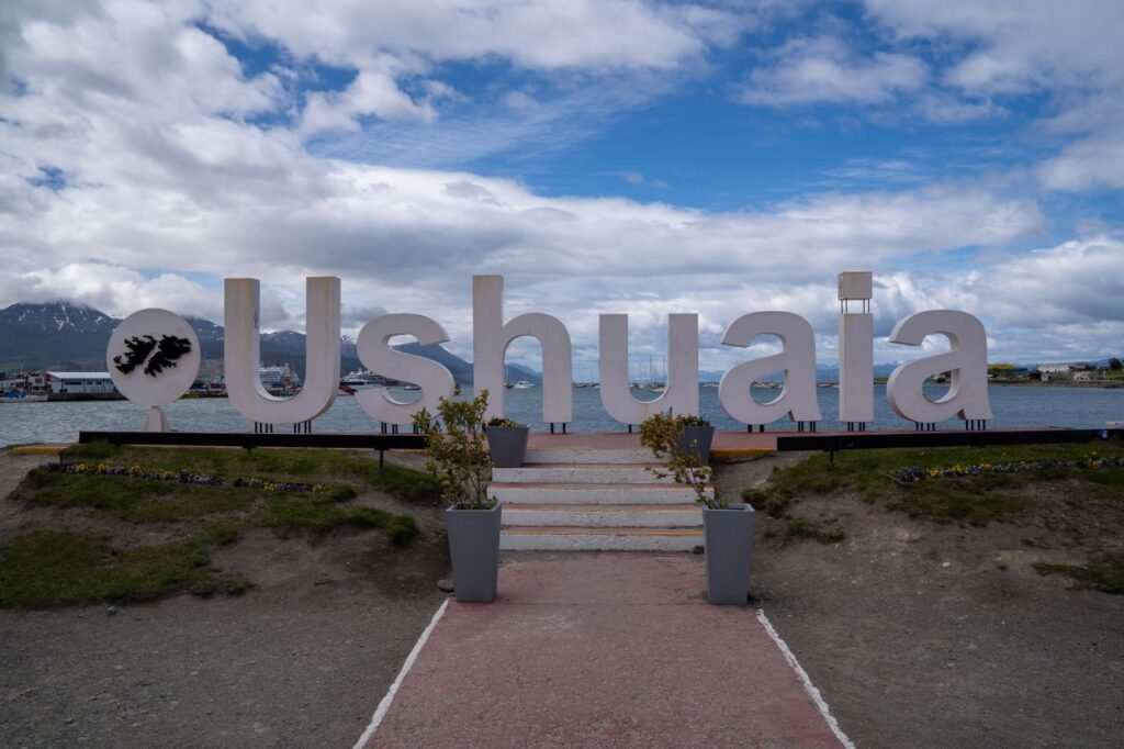 Cartel turístico con el nombre de Ushuaia junto al paisaje natural de la ciudad más austral del mundo, en Tierra del Fuego.